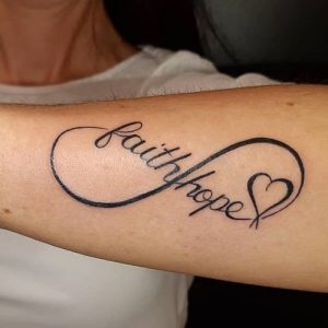 black infinity heart forearm tattoo with written text